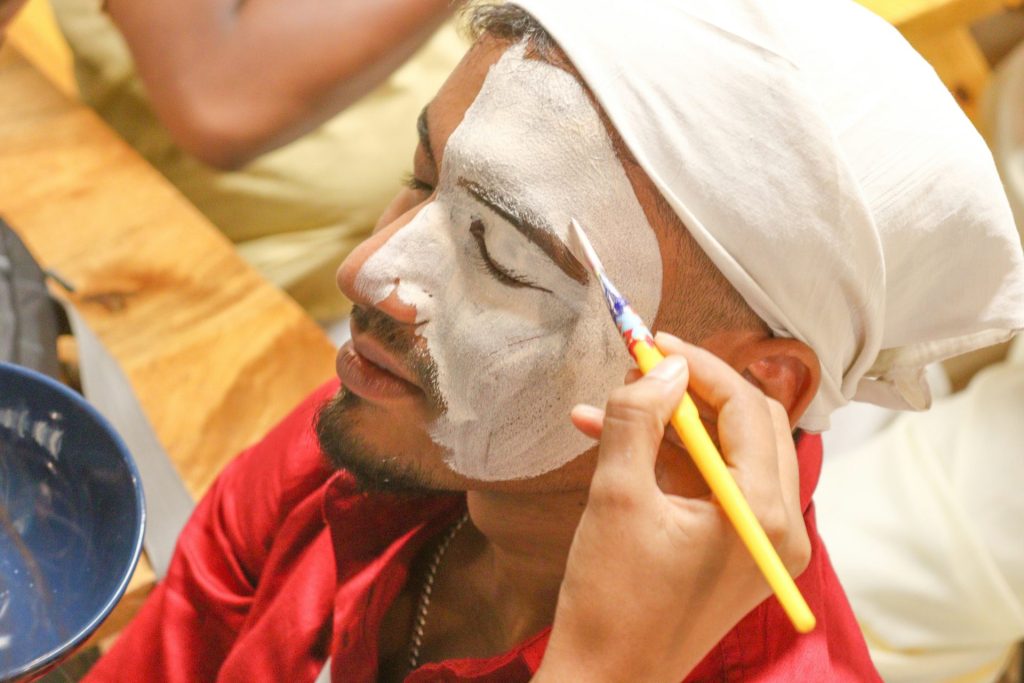 a man is shaving his face with a yellow toothbrush